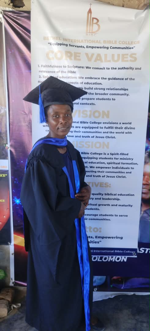 A graduate in a black gown and blue sash