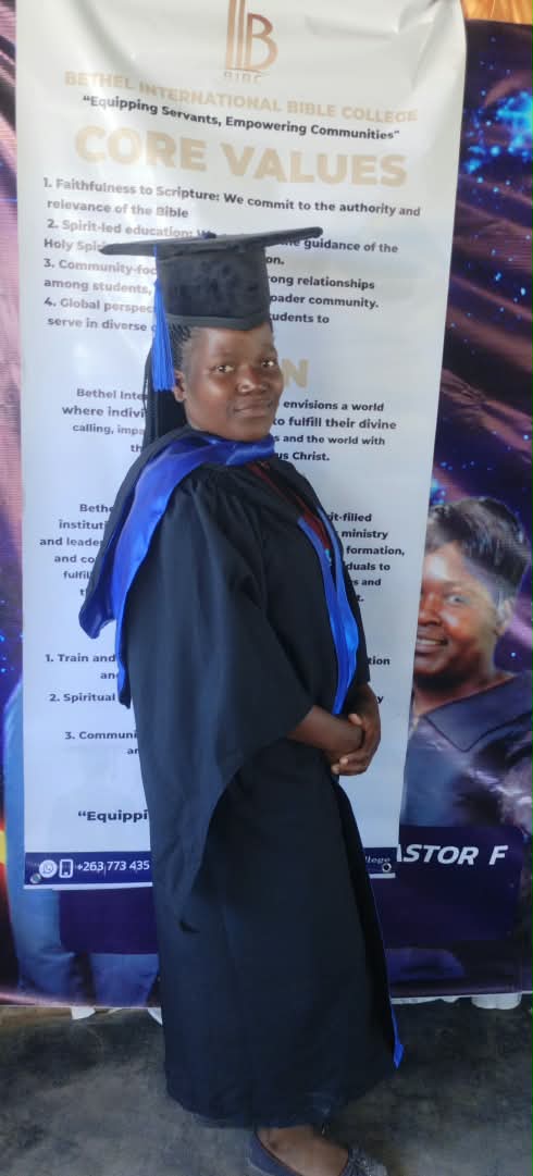 A graduate in a black gown and blue sash