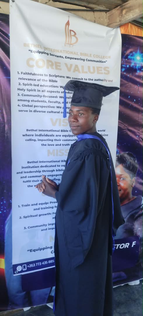 A graduate in a black gown and blue sash