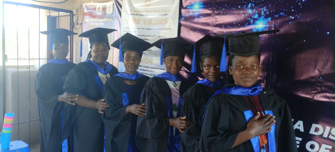 Six Bethel International Bible College graduates in black gowns and blue sashes
